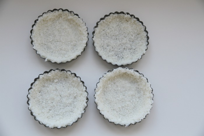 Minipaier med bunn laget av kokos, sukker og eggehvite. Fylt med sitronkrem og toppet med ferske bær. Disse paiene er supergode og enkle å lage. 